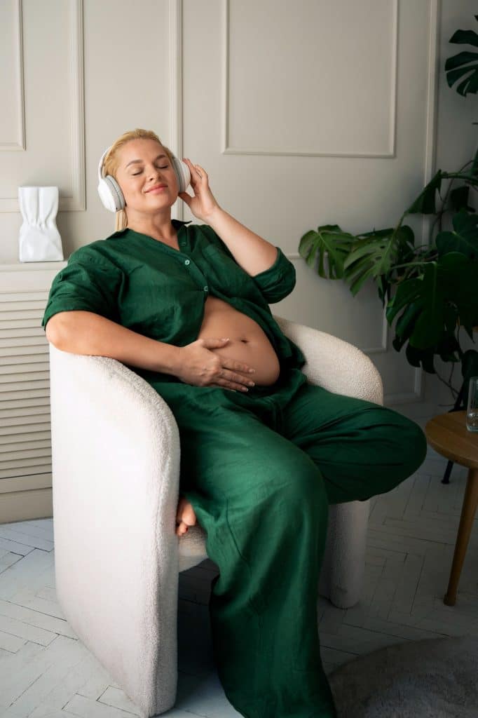 Femme enceinte souriante après une séance d'ostéopathie chez Synapsia